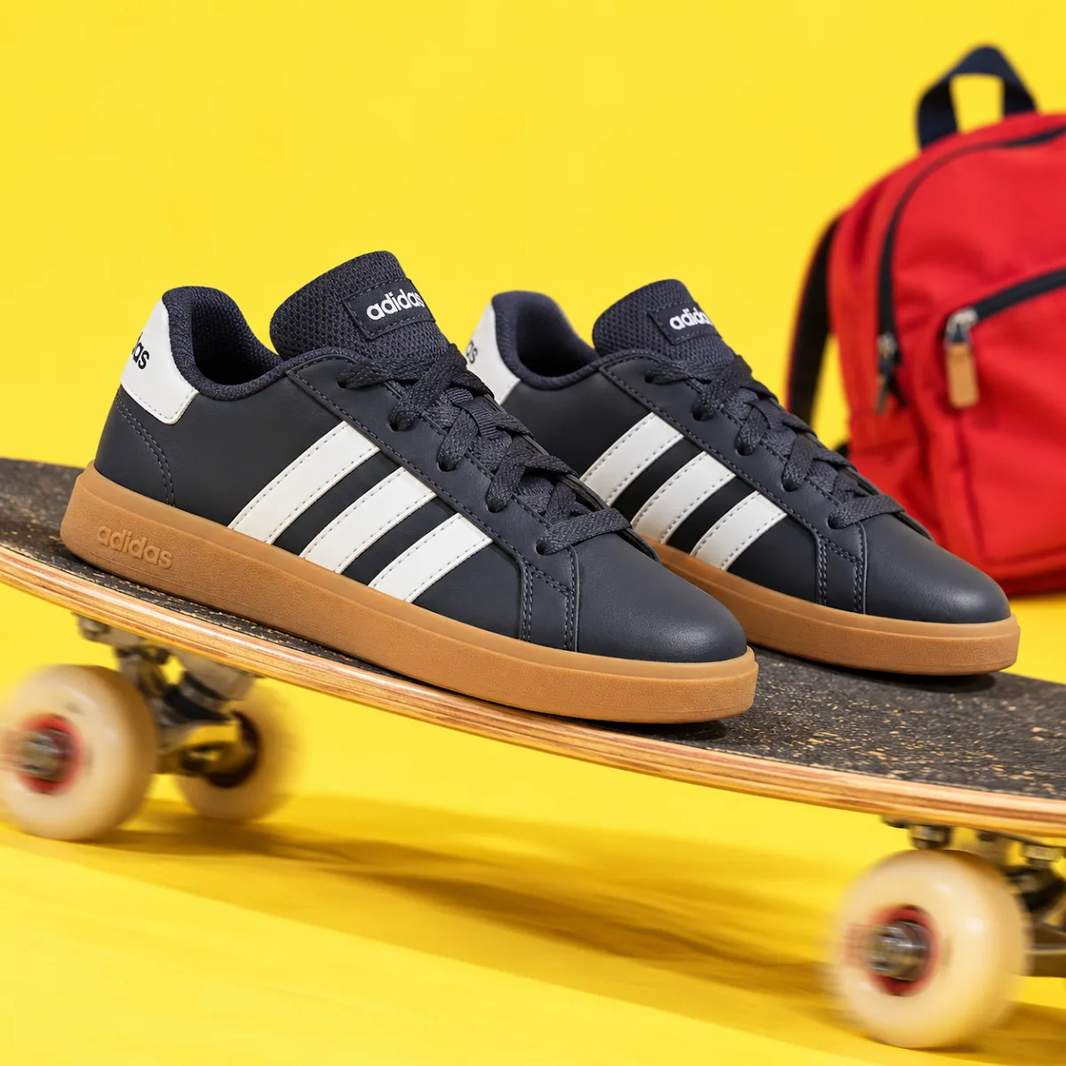 Grand Court Base 00s marine garçon Adidas sur un skateboard